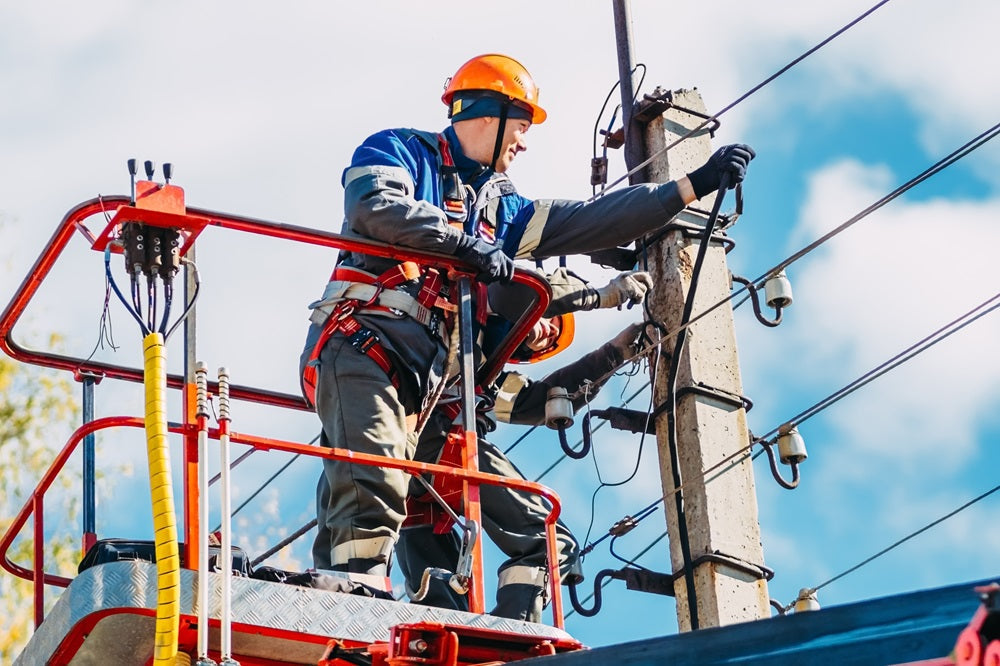 Lineman working on electrical wires with Electrical Hazard (EH) protection boots on