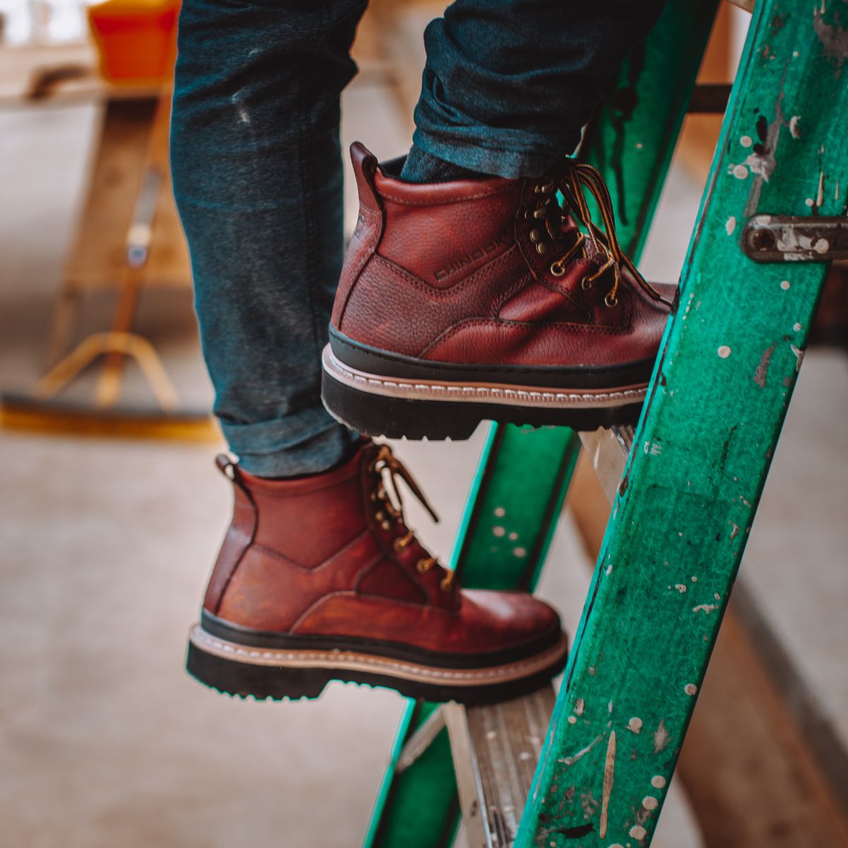 Side view of Workhorse II 6" Soft Toe Men’s Work Boots in Brown as a man steps up a ladder. The boots feature durable leather, a sturdy sole, and a classic lace-up design, perfect for providing comfort and support during light-duty work.